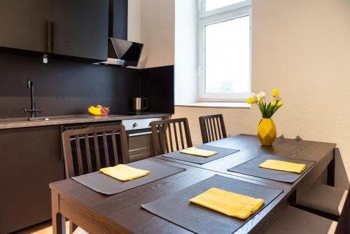 una cocina con una mesa de madera con un jarrón de flores. en Spacious Family Apartment at Mauerpark plus SelfCheckIn, en Berlín