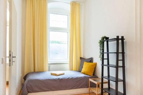 a small bedroom with a bed and a window at Spacious Family Apartment at Mauerpark plus SelfCheckIn in Berlin