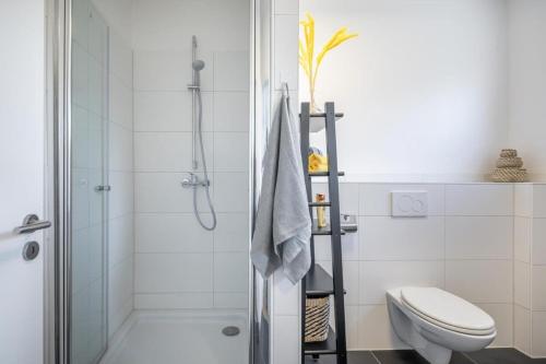 a white bathroom with a shower and a toilet at Modern Apartment for 6 close to the Schanzenviertel - Unit 2 in Hamburg