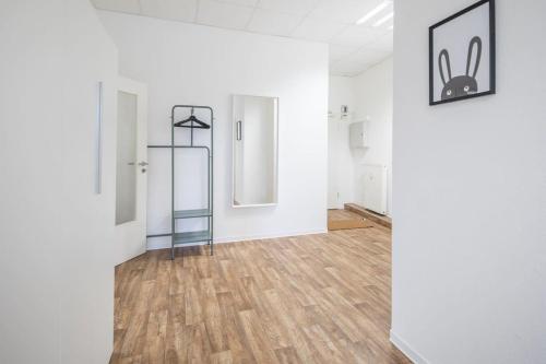 Habitación vacía con paredes blancas y suelo de madera. en Spacious 2 BR Apartment Hamburg, en Hamburgo