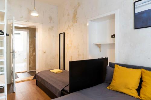 a room with a bed and a couch with yellow pillows at Shabby Chic plus Self CheckIn and Free Street Parking in Berlin