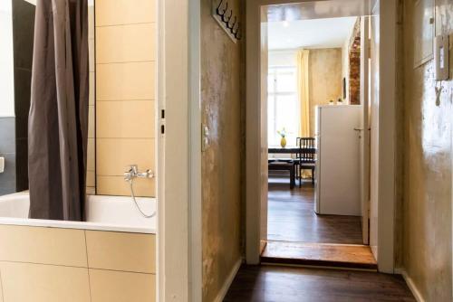 a bathroom with a tub and a refrigerator in a room at Shabby Chic plus Self CheckIn and Free Street Parking in Berlin