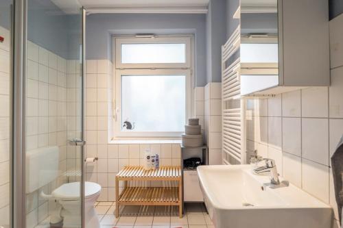 baño con lavabo y aseo y ventana en Two Bedroom Apartment and Bathrooms, en Hamburgo