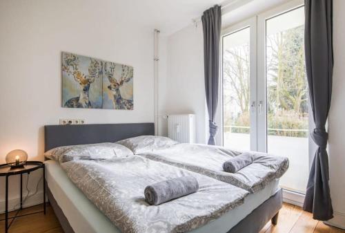 1 dormitorio con 1 cama con 2 almohadas en Schickes zwei Zimmer Apartment Kostenl Parkm auf der Strasse, en Hamburgo