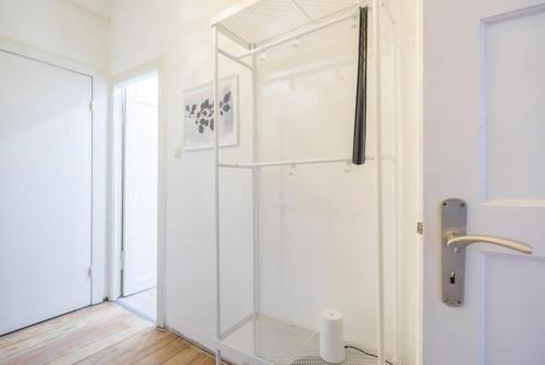 a glass shower stall in a white bathroom at Cosy 2-room Apartment in urban location in Hamburg