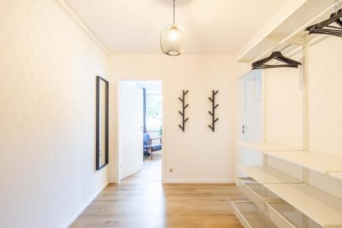 Habitación con paredes blancas y pasillo con suelo de madera. en 3 Bedroom apartment in great location, en Hamburgo