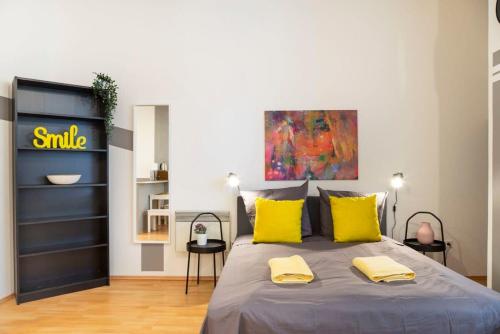 1 dormitorio con 1 cama grande con almohadas amarillas en Cozy 2 room apartment next to Hermannstraße en Berlín