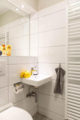 a white bathroom with a sink and a toilet at SPACIOUS Two BR plus AC plus SelfCheckIn in Berlin