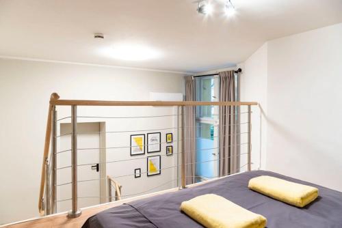 a bedroom with a bed with two yellow pillows at SPACIOUS Two BR plus AC plus SelfCheckIn in Berlin