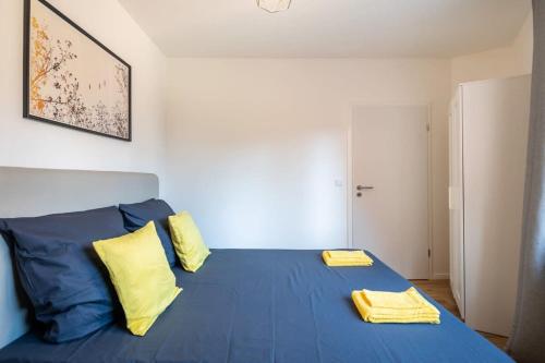 a bedroom with a blue bed with two yellow pillows at 1 Schulterblatt-Apartments Hamburg For 6 in Hamburg