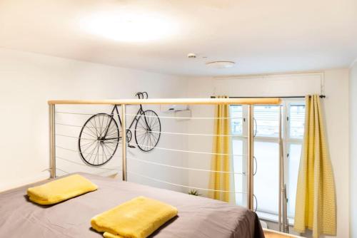 una bicicletta appesa a un muro sopra un letto di Loft Apart plus AC plus SelfCheckIn a Berlino