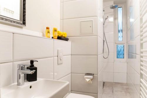 bagno bianco con lavandino e doccia di Loft Apart plus AC plus SelfCheckIn a Berlino