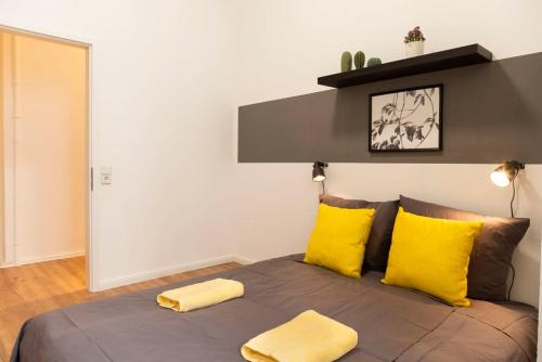 een slaapkamer met een bed met gele kussens bij Modern 2 Bedroom Apartment in Berlin Schöneberg in Berlijn