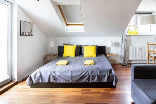 une chambre avec un grand lit avec des oreillers jaunes dans l'établissement Urban Rooftop Apartment - Berlin MITTE - A C, à Berlin