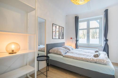 1 dormitorio con cama y ventana en Spacious Two BR Close To Stadtpark and Street Parking, en Hamburgo