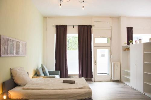 a bedroom with a bed and a chair and a window at Family Apartment Moabit in Berlin