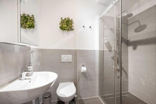 a bathroom with a sink and a toilet and a shower at Apartment close to Theresienwiese in Munich