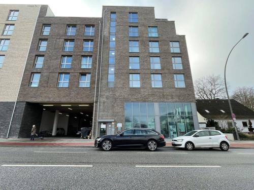 deux voitures garées devant un immeuble dans l'établissement Urban Living - Top Floor Apartment, à Hambourg