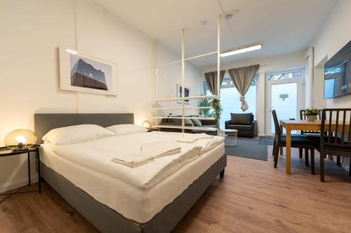 a bedroom with a large bed and a dining room at Apartment 2 Hamburg Winterhude in Hamburg