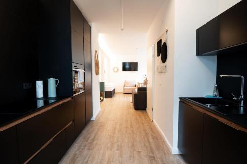 a kitchen with black cabinets and a wooden floor at Hamburg - Cosy Apartment for 4 in Hamburg