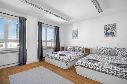 Munich Gem - 2 Bedroom Alpine View Tranquility في ميونخ: غرفة بيضاء بسريرين واريكة