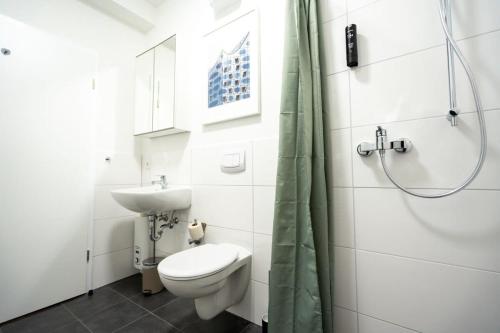 uma casa de banho com um WC, um lavatório e um chuveiro em Living in Hamburg City Center em Hamburgo