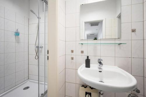 bagno bianco con lavandino e doccia di Munich Gem - 2 Bedroom Alpine View Tranquility a Monaco