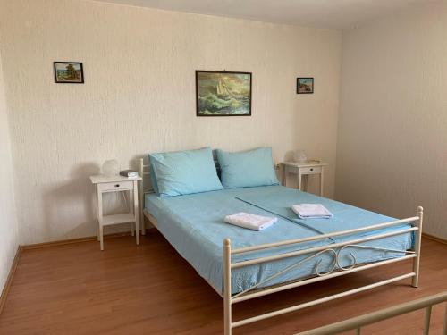 a bedroom with a bed with blue sheets and two tables at Apartments Jaca in Rab