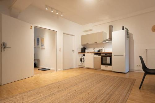 a kitchen with a refrigerator and a chair in a room at Hamburg City Center Apartment in Hamburg