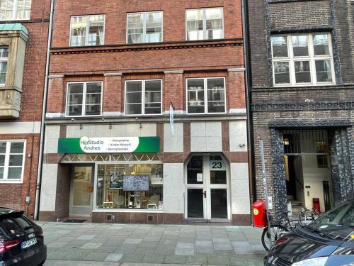 a brick building with a store on a street at Hamburg City Center Apartment in Hamburg