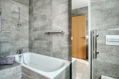 a bathroom with a white tub and a shower at Marina Luah in Benissa