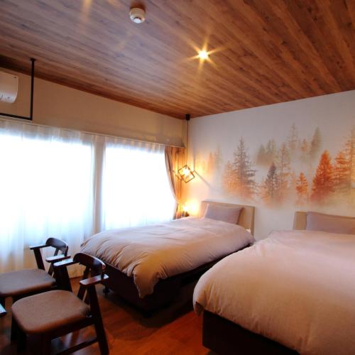 a hotel room with two beds and a window at みつまたロッヂ in Yuzawa