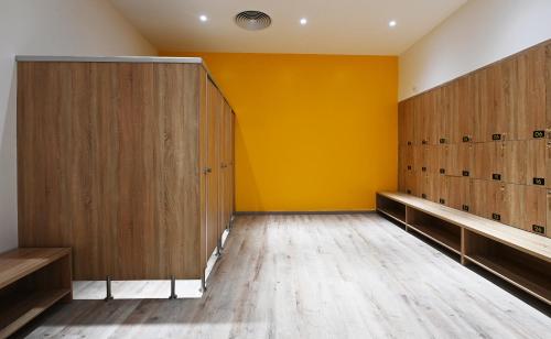 a locker room with wooden doors and a yellow wall at The Empyrean Cam Ranh Beach Resort in Cam Ranh