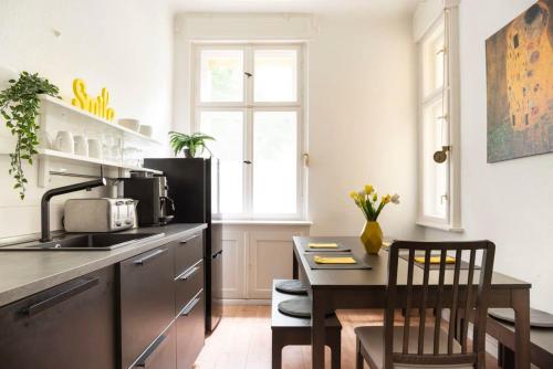 une cuisine avec un comptoir et une table avec des chaises dans l'établissement Stylish Loft Apartment plus SelfCheckIn plus Street Parking, à Berlin