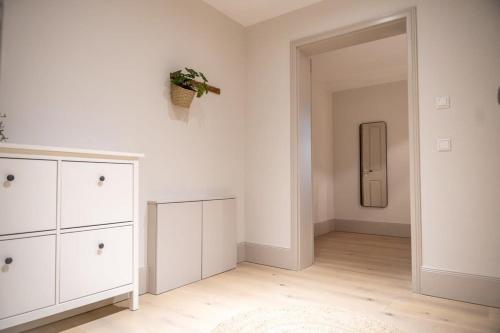 a white room with a dresser and a mirror at Spacious 3-bedroom apartment near Eilbekpark in Hamburg