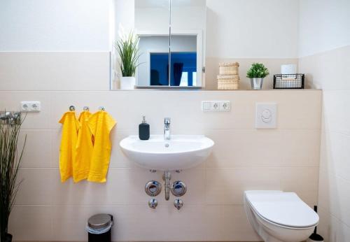 a white bathroom with a sink and a toilet at Four Bedroom in urban location in Hamburg