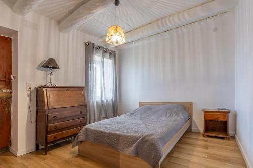 - une chambre avec un lit, une commode et une lampe dans l'établissement Casa Calma - Maison à proximité des plages, à Figari