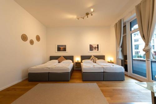 two beds in a room with a window at Großzügige Wohnung in der Nähe vom Quartierpark in Hamburg