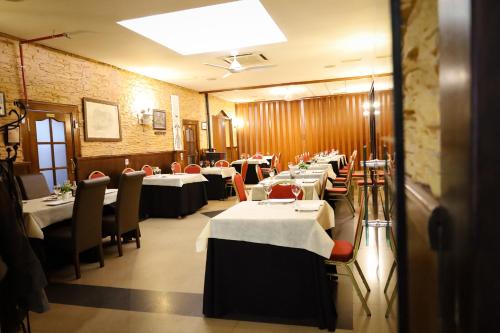 a row of tables in a restaurant with white tables and chairs at Hospedium DLJ Hostal Ben Nassar in Arjona