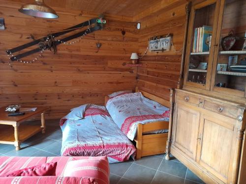 een slaapkamer met 2 bedden in een houten kamer bij Gîte le Clapier in Theys
