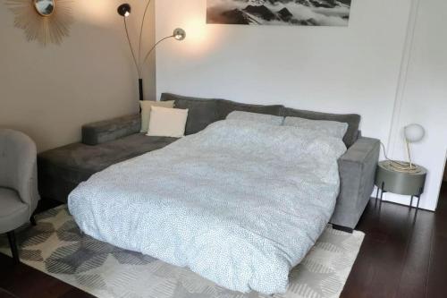 une chambre avec un grand lit et un canapé dans l'établissement EXIGEHOME - Beautifull T2 near Versailles Saclay & Chevreuse, à Voisins-le-Bretonneux