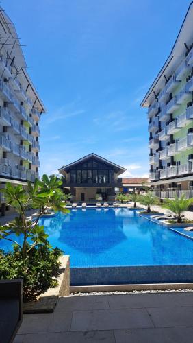 a large swimming pool in front of a building at Zhamira Avior's Condominium in Mactan
