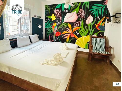 1 dormitorio con 1 cama con pared de flores en Tribe Bayahibe, en Bayahibe