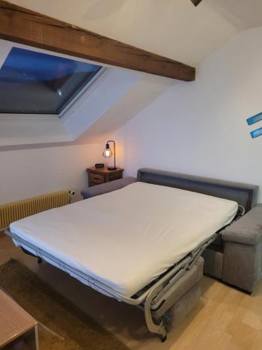 ein Krankenhausbett in einem Zimmer mit Fenster in der Unterkunft Le Trésor des Vosges Appartement spacieux et lumineux 80m2 idéal famille 4 à 6 personnes in Gérardmer
