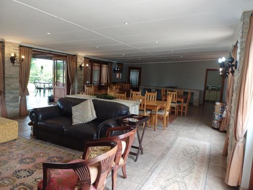 a living room with a couch and a table and chairs at Bydand Guest House in Addo