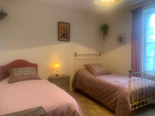 1 dormitorio con 2 camas y ventana en Treignac Tourelles, en Treignac