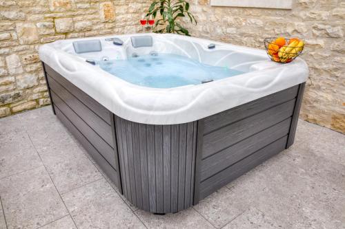 a jacuzzi tub with a bowl of fruit on top at House Peroj 1765 in Peroj