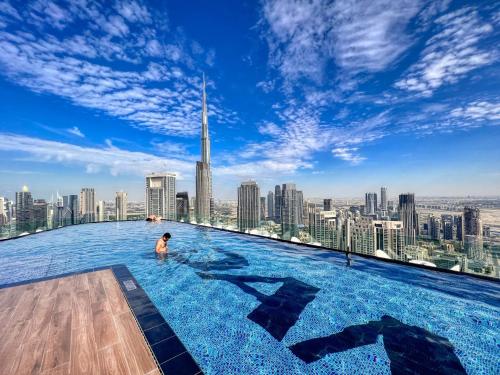 a man in a infinity pool on the top of a skyscraper at Dubai Scenic Infinity Pool with Burj Khalifa Views in Dubai