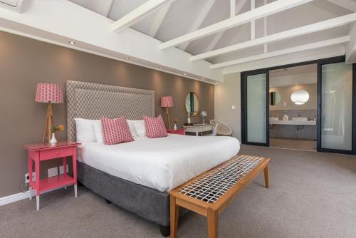 a bedroom with a large bed and a table at Banhoek Lodge in Stellenbosch