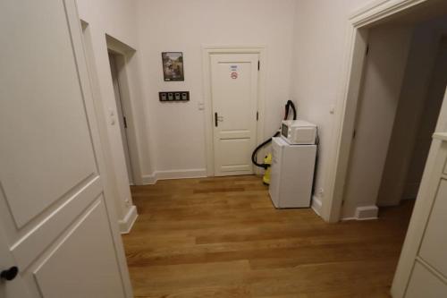 a hallway with a white door and a refrigerator at Fantastic - KP22 Room A in Warsaw